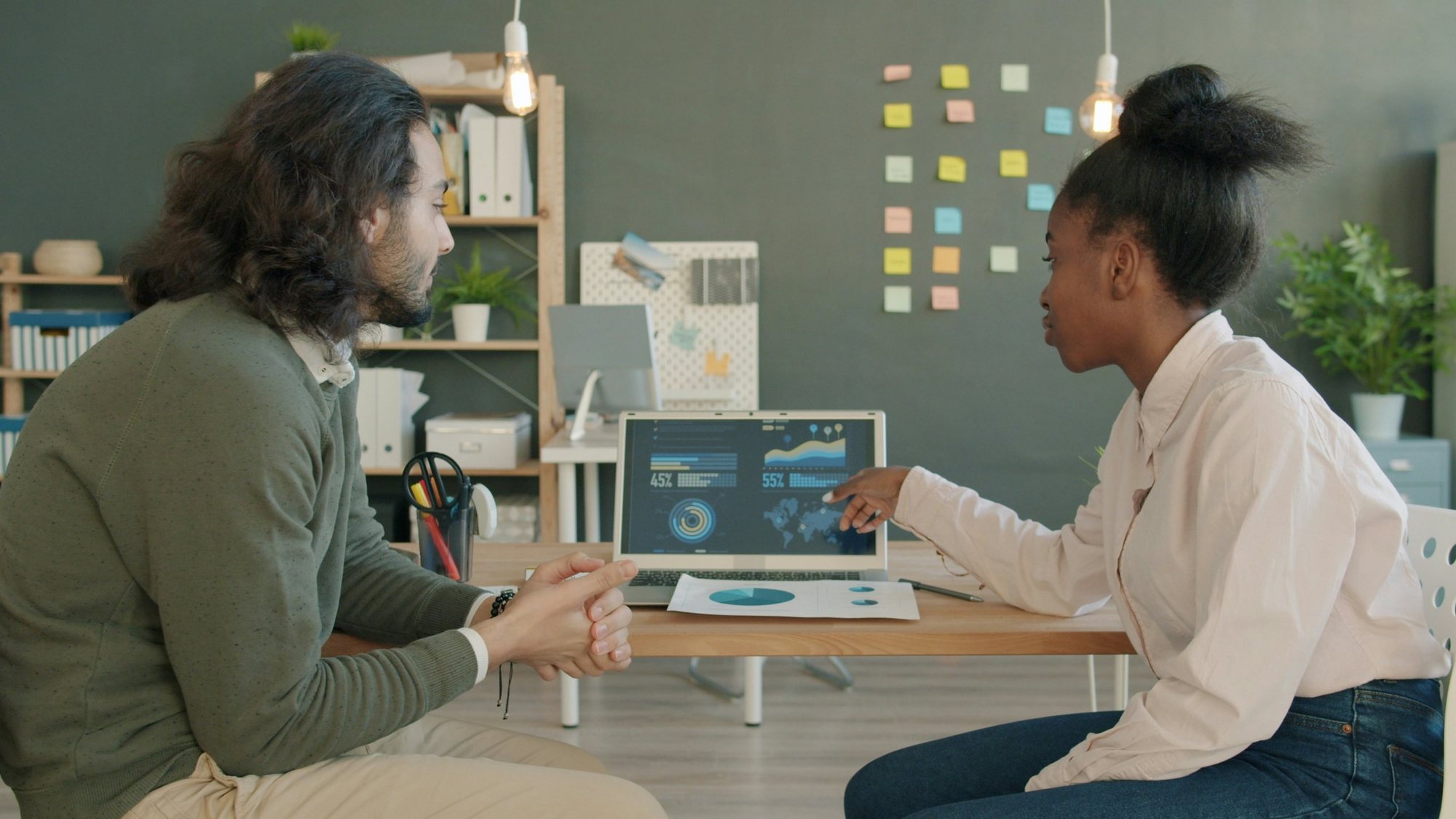 Two colleagues reviewing information together on a laptop